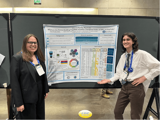 Two students in front of a scientific poster